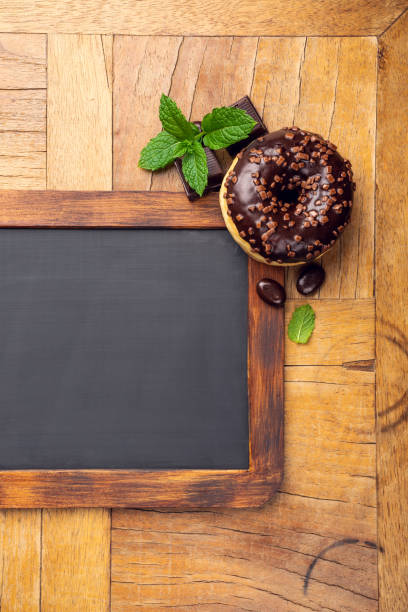 istock Black chalkboard with chocolate glazed donut 1044975572