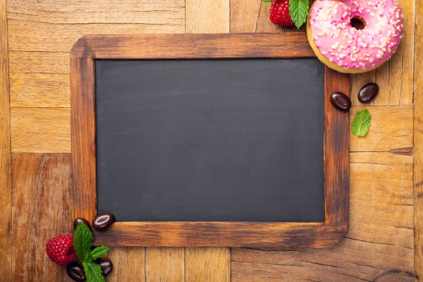 istock Black chalkboard with pink glazed donut 1044975582