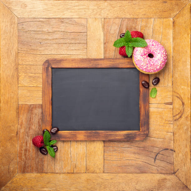 istock Black chalkboard with pink glazed donut 1044975586