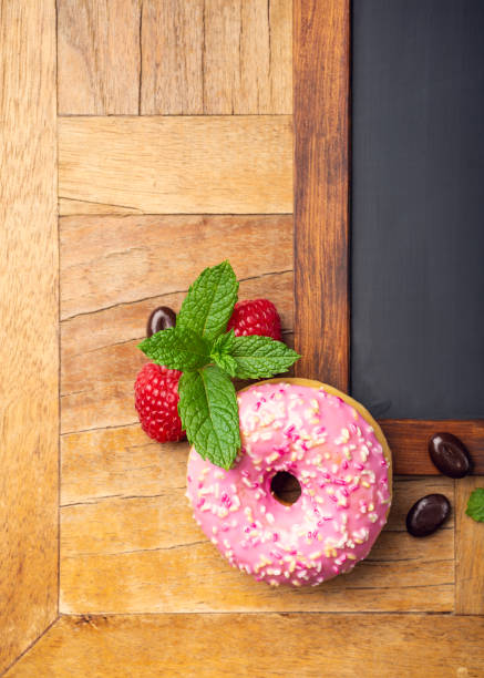 istock Black chalkboard with pink glazed donut 1044975590