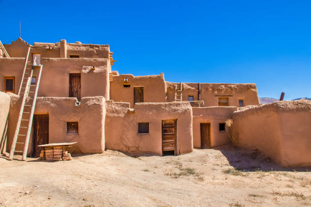 Multi-story adobe buildings from Taos Pueblo in New Mexico where Indigenous people are still living after over a thousand years Multi-story adobe buildings from Taos Pueblo in New Mexico where Indigenous people are still living after over a thousand years adobe material stock pictures, royalty-free photos & images