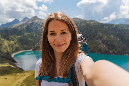 self portrait of a girl on a mountain peak during a sunny day. lake ritom