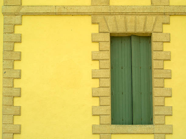 istock Window with green shutters in yellow wall 104499299