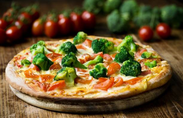 Freshly Baked Pizza with Vegetables Fresh baked pizza with broccoli florets, sliced tomatoes drizzled with Hollandaise sauce. hollandaise sauce stock pictures, royalty-free photos & images