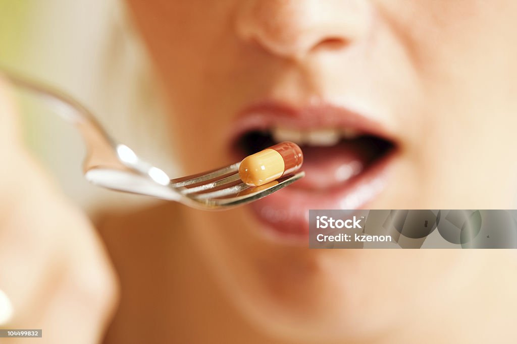 Женщина ест пищевые добавки - Стоковые фото Благополучие роялти-фри