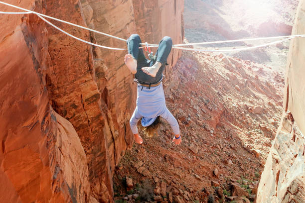 istock Crazy man hanging upside down on the slackline - highline 1045002504