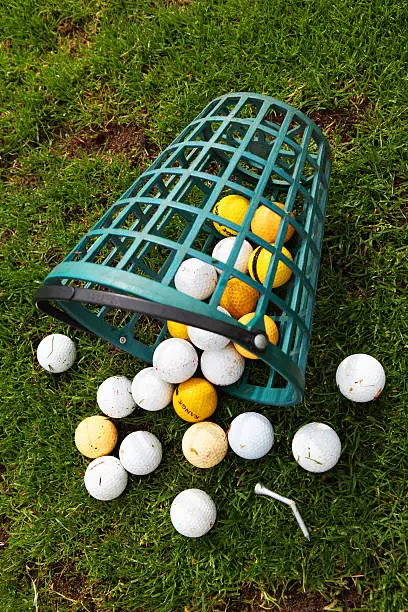 Practice golfballs and bucket with broken tee on green gras /// FOR MORE PICS PLEASE CLICK HERE: