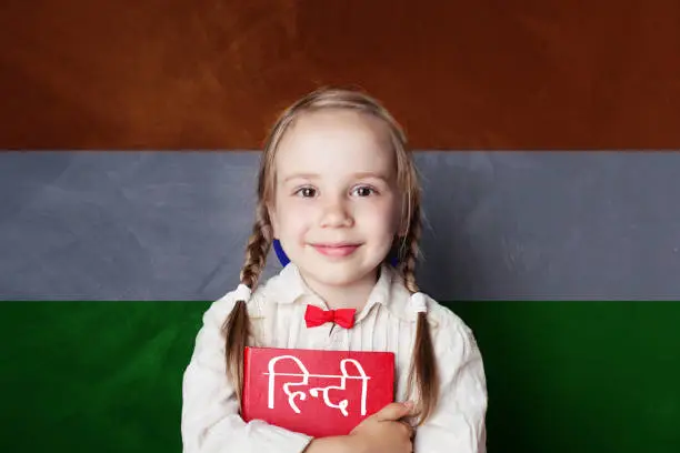 Photo of Learn hindi language. Smart child student on India flag background