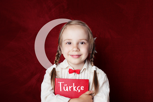 Concepto de lengua turca. Niño lindo estudiante de chica en el fondo de la bandera de Turquía. Aprender idioma Turco photo