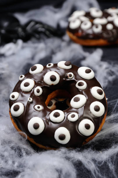 istock Donuts with chocolate icing decorated googly eyes on Halloween 1045009052