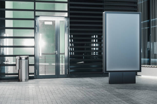 istock Blank banner stand next to facade of modern building at night, 3d rendering. 1045009328