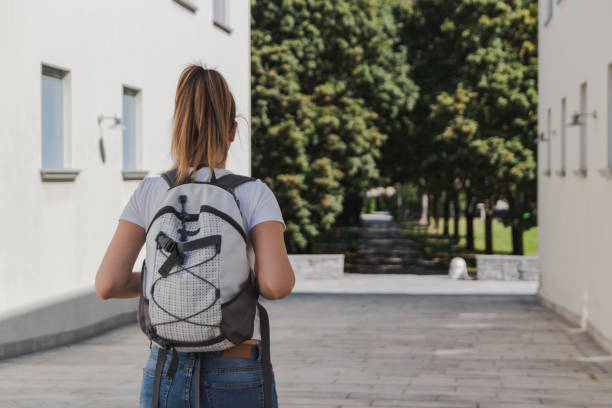 istock young woman with backpack walking to school after summer holidays 1045011978