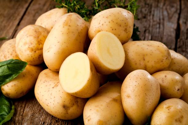 des pommes de terre sur fond de bois - raw potato organic rustic bag photos et images de collection