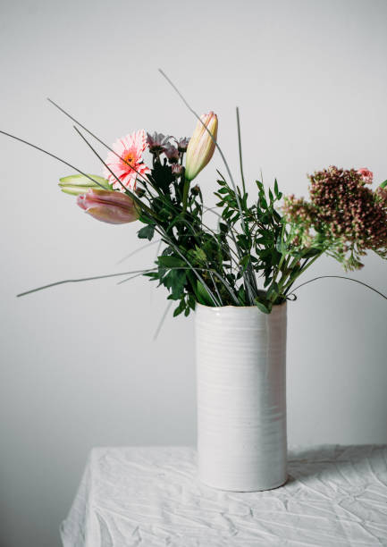 istock Served table for event dinner, decorated with floral compositions in vases in pink and coral shades. Scandinavian style concept 1045017968