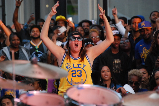 A woman in a Draymond Green jersey cheers for the Golden State Warriors at a watch party in Oakland as the team closed in on a sweep of the Cleveland Cavaliers in the NBA Finals.