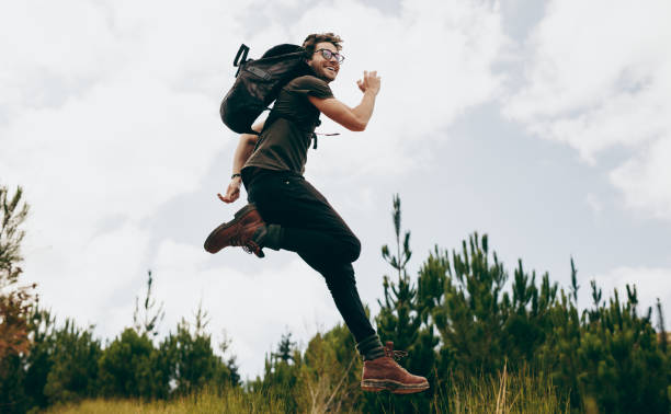istock Happy man jumping during his walk in the forest 1045026044