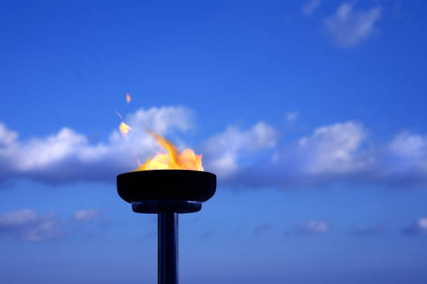 istock Close up burning flaming torch over cloudy sky 1045026572
