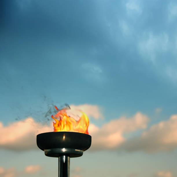 istock Close up burning flaming torch over cloudy sky 1045026880