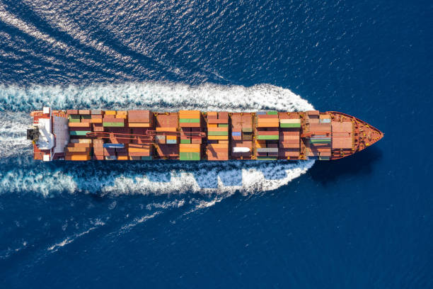 istock Aerial view of a large container ship in motion over blue, open ocean 1045032628