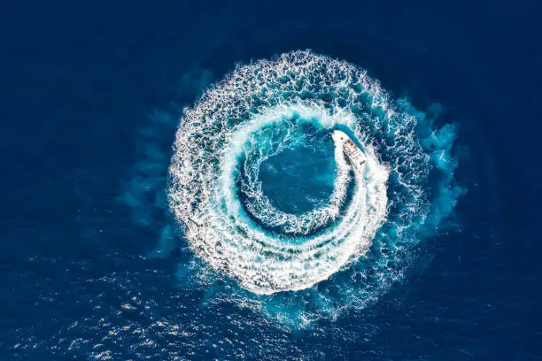 Photo of Motorboat forms a circle of waves and bubbles with its engines