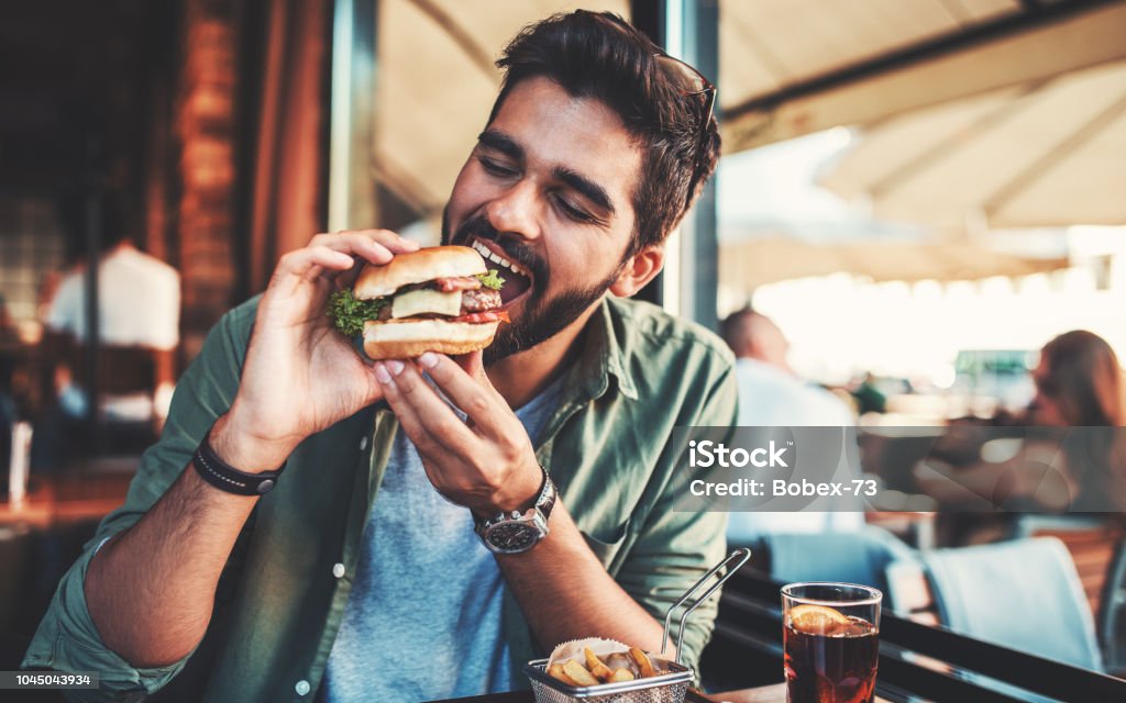 Breakfast in a cafe. Food, lifestyle concept Young man sitting in a cafe and enjoying in breakfast. Food, lifestyle concept Eating Stock Photo