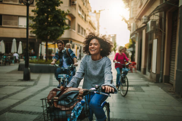 giovani che esplorano la città in bicicletta - cycling bicycle women city life foto e immagini stock