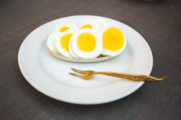 Egg on two forks on black background