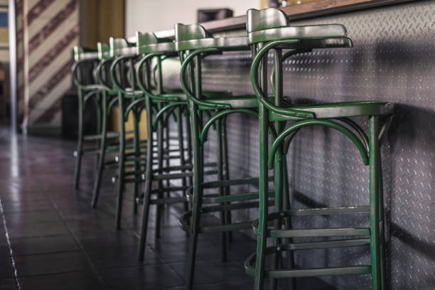 istock Vintage green bar stools stand in a row next to the bar counter. Horizontal frame 1045049048