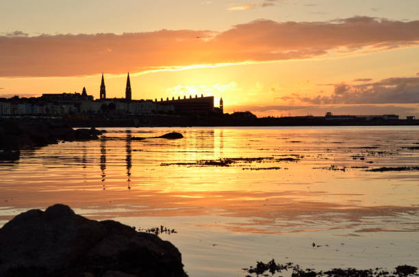 Calm sea reflects light of setting sun. stock photo