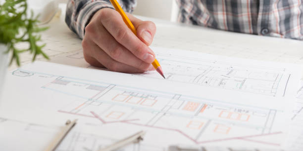 istock Architects working on blueprint, real estate project. Architect workplace - architectural project, blueprints, ruler, calculator, laptop and divider compass. Construction concept. Engineering tools. 1045079732