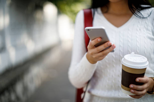 istock Woman using mobile phone outdoor 1045082378
