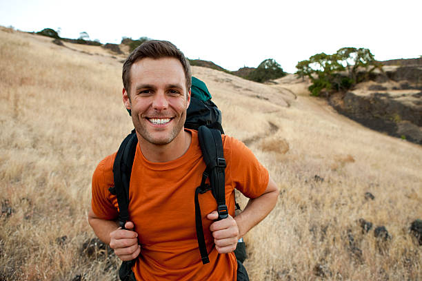 male smiles while hiking in the outdoors. - day washington state vertical outdoors fotografías e imágenes de stock