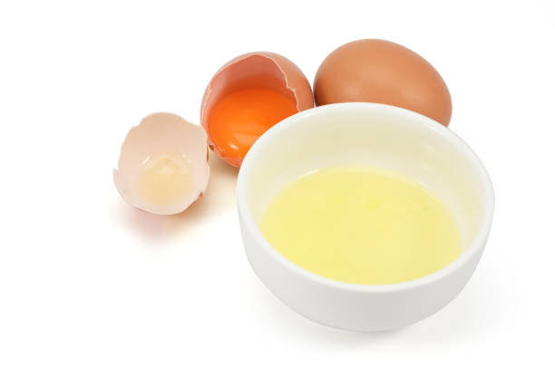 istock white egg in the cup and egg yolk in a eggshell isolated on white background. 1045151960