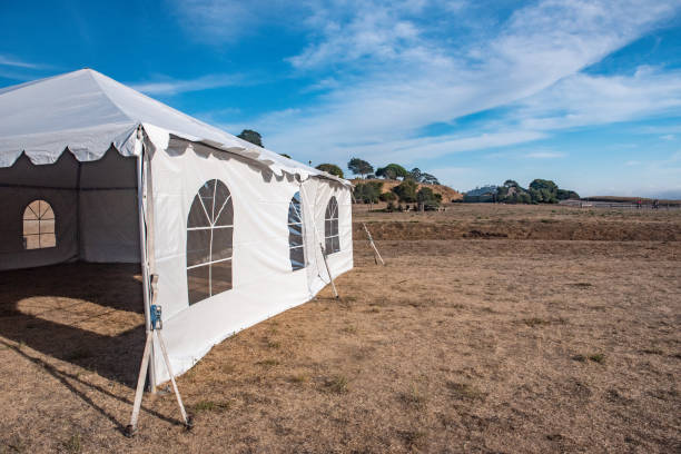 istock White tent in brown grass field under blue sky 1045152272