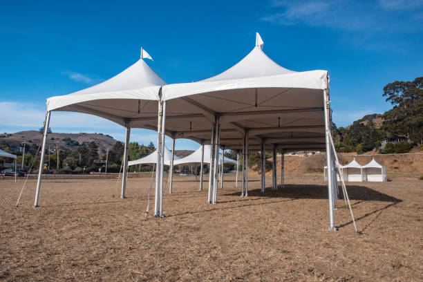 istock White tent in brown grass field under blue sky 1045152292