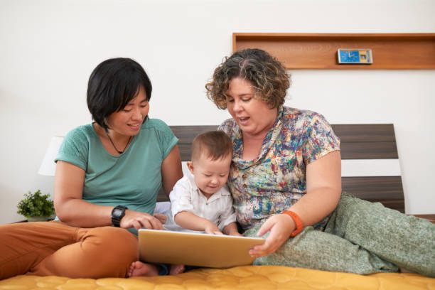 madri che giocano con i bambini - child digital tablet mother teaching foto e immagini stock
