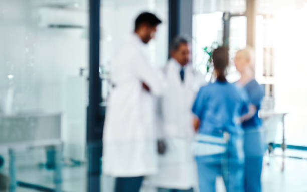 The experts are always on the job Defocused shot of a group of medical practitioners working in a hospital healthcare and medicine concept stock pictures, royalty-free photos & images