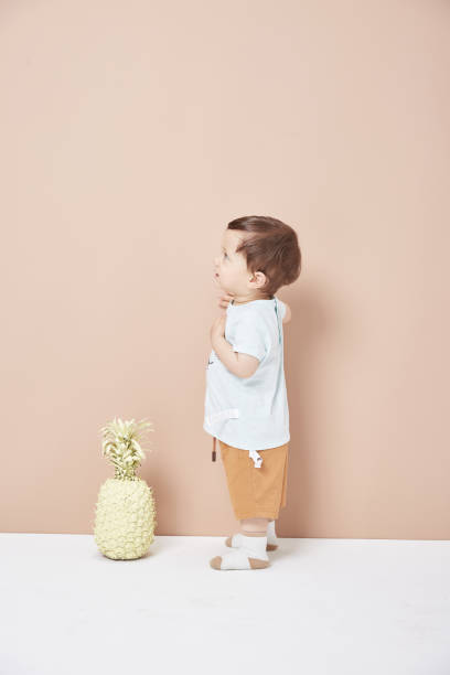 istock A one and a half year old boy learned to walk on the wall. 1045206066