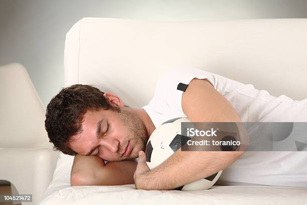 Young Man Sleeping With Ball On Sofa Stock Photo - Download Image Now - Adult, Boys, Casual Clothing