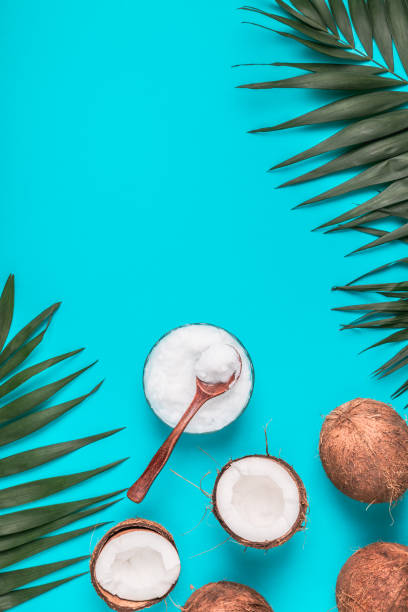 istock Coconut oil and coconuts on a background with tropical leaves 1045218200