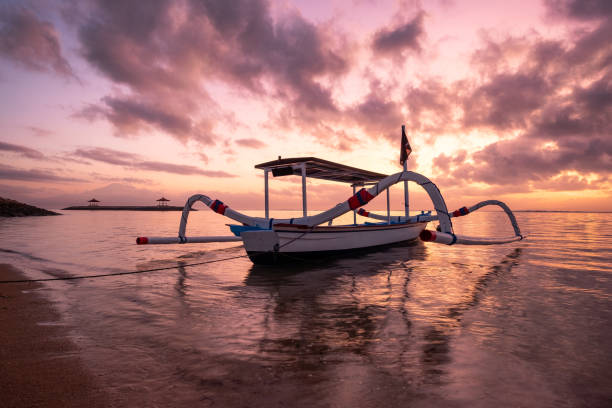 barco de pesca tradicional antigua de janggolan a orilla del mar al amanecer colorido - jukung fotografías e imágenes de stock