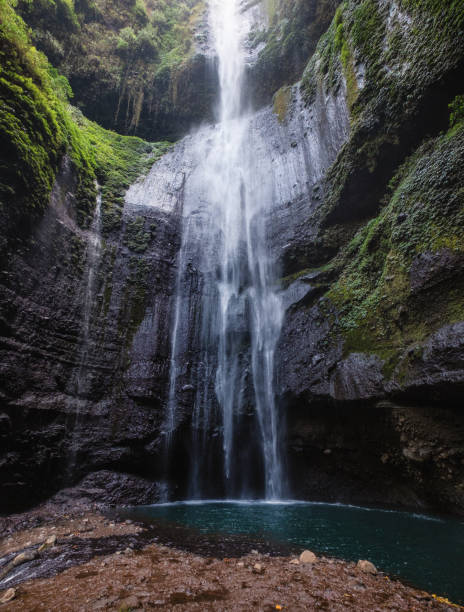 istock Majestic waterfall flowing on rock cliff in rainforest 1045220976