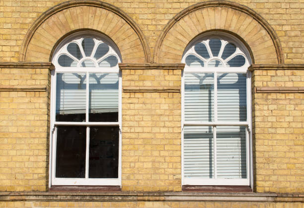 due finestre a fascia bianca in legno vittoriano con pannelli di vetro su un classico muro di mattoni gialli con tende bianche - london england sash window house georgian style foto e immagini stock