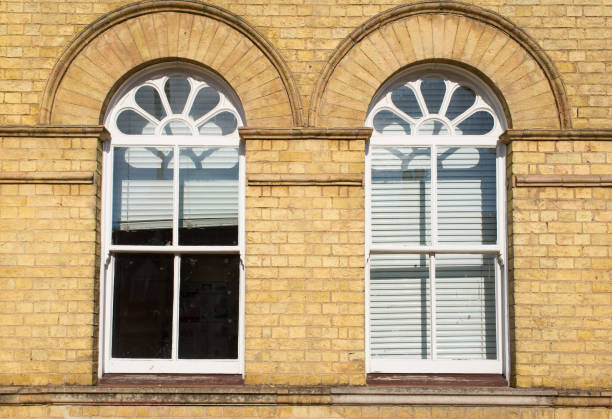 two victorian wooden frame white sash window with glass panels on a classic yellow brick wall with white blinders curtains - london england sash window house georgian style imagens e fotografias de stock