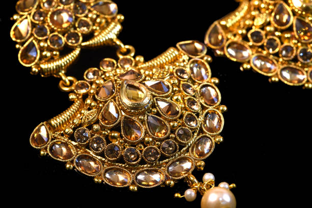 istock Fancy designer golden earring set closeup macro image on black background 1045248684
