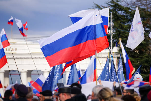 Russian Patriotic holiday with flags and concerts in the city square. Sevastopol, Crimea-March 18, 2015: Russian Patriotic holiday with flags and concerts in the city square. People stand under Russian flags in the main square. crimea photos stock pictures, royalty-free photos & images