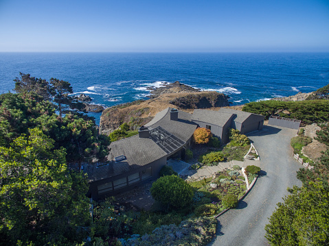 Drone aerial view of house by pacific ocean in Sonoma Mendocino California on sunny day by ocean