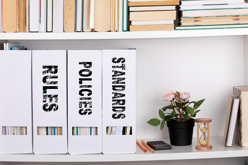 Standards, Policies and Rules. document folders and organizers, white book shelf
