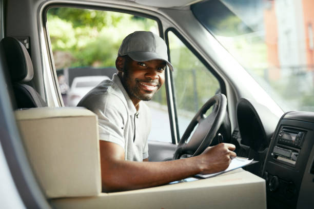 istock Courier Delivery. Black Man Driver Driving Delivery Car 1045263396