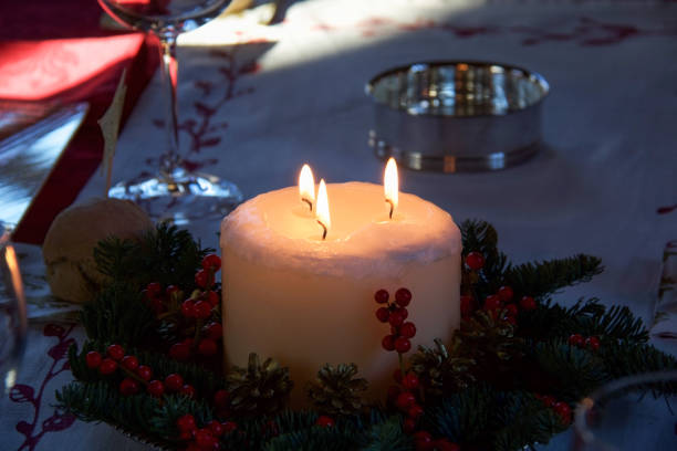istock christmas candle with three flames  and red berries as  table decoration 1045265596